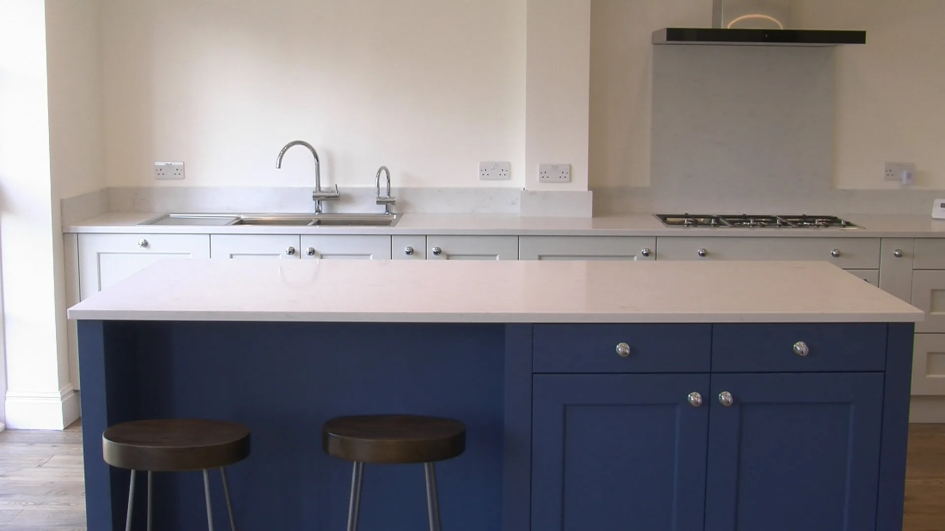 Blue shaker kitchen island with white quartz worktop at the Hill Crescent renovation