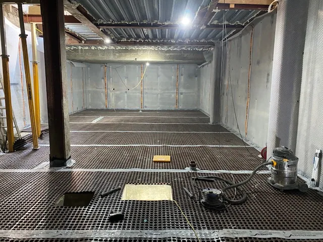 Cavity drain membrane being fitted during a basement conversion