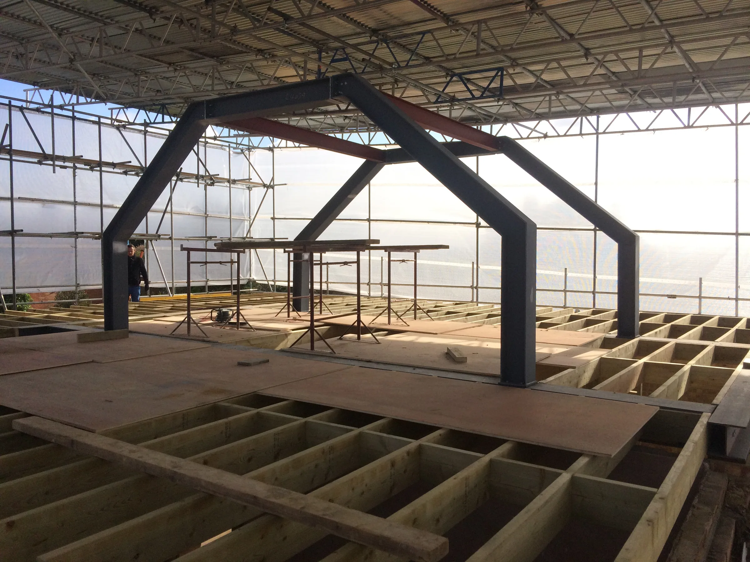 Steel portal frame installed for a loft conversion beneath a temporary scaffold roof